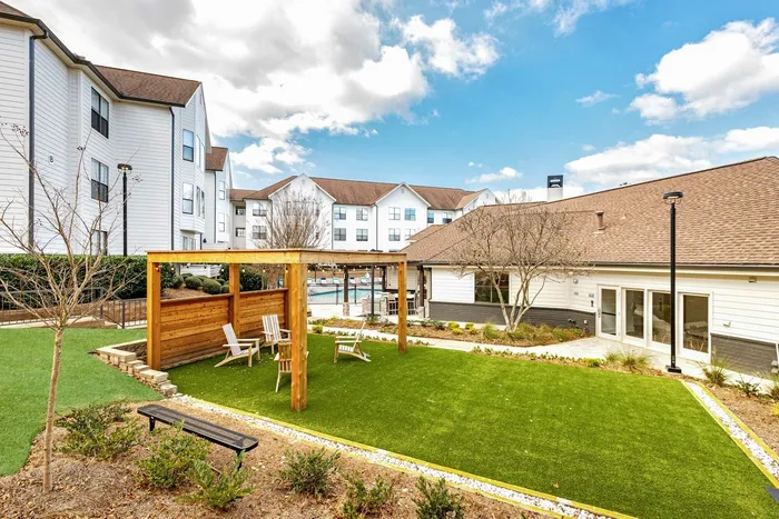 View of the community with greenspace and a gazeebo with seating in the day time