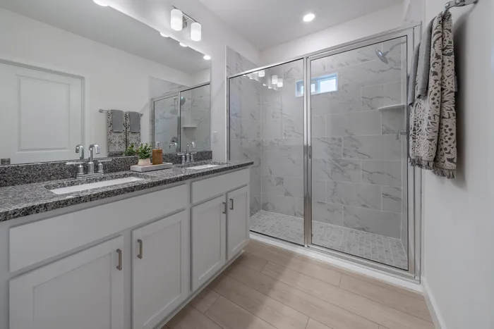 Bathroom with two sinks and standing glass shower