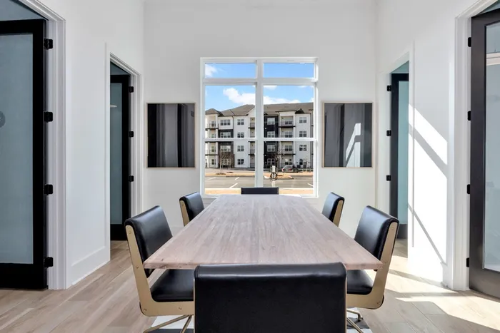 2 BR Apartments in Athens AL - Gateway Village - Conference Room with a Long Table and Office Chairs, Wood Flooring, and a Large Window