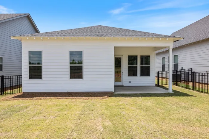 Opelika, AL Houses Near Auburn University - Champions Square - Front View of Single-Story Home with White Plank-Style Exterior Walls, Front Door with Porch Area, Windows, and Front Lawn with Manicured Grass.