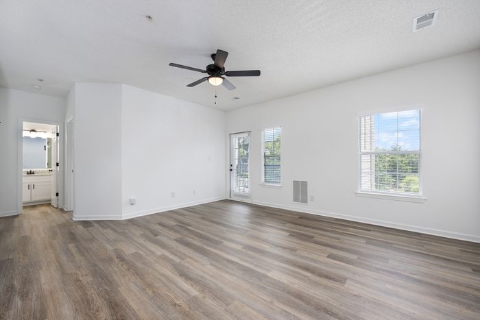 Unfurnished living room with wood style flooring and lighted ceiling fan