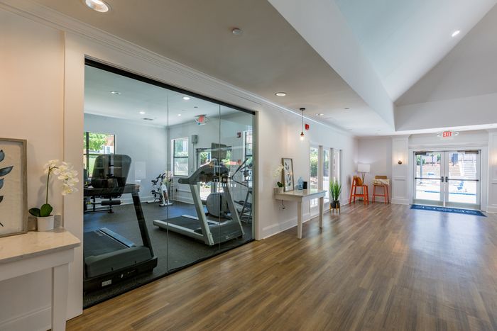 room with glass peeking into furnished fitness center