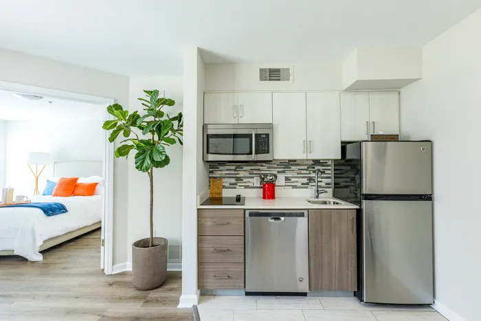 furnished kitchen and bedroom area of apartment home