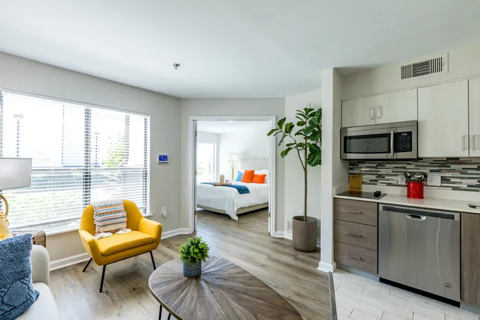 furnished kitchen, living and bedroom area of apartment home