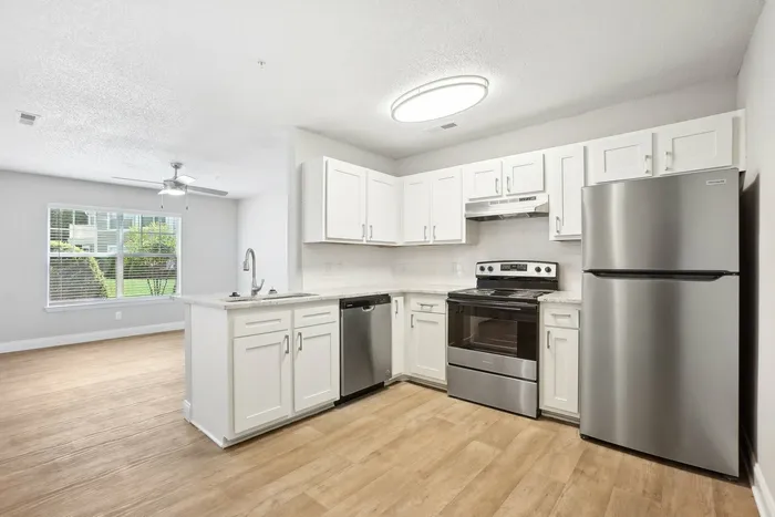 Kitchen with luxury plank flooring and white cabinets