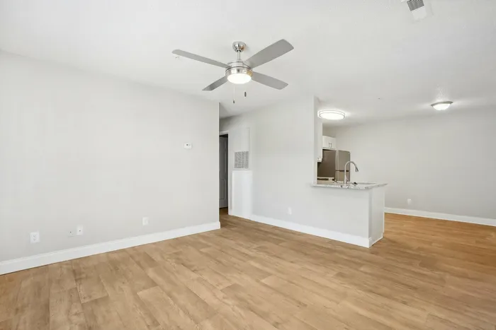 Living room with luxury plank flooring and ceiling fan