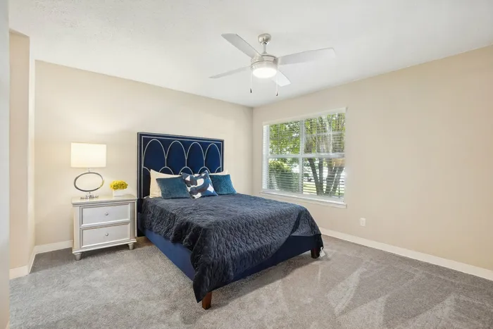 Bedroom with plush carpet and ceiling fan