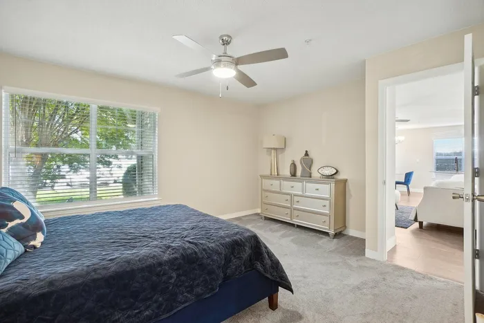 Bedroom with plush carpet and ceiling fan