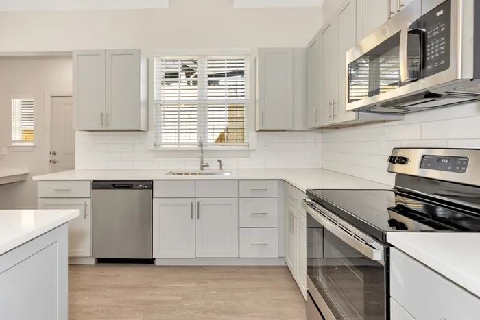 Kitchen with light cabinetry and stainless steel appliances