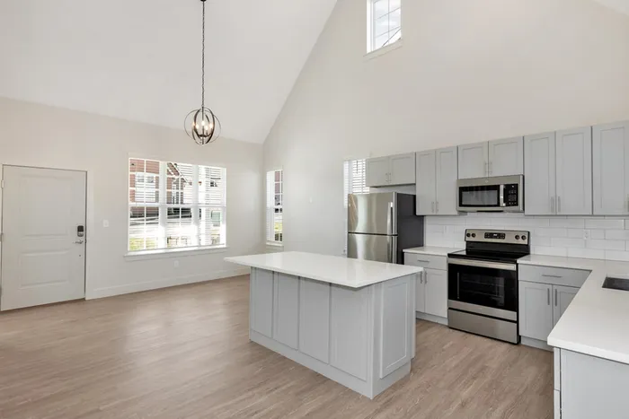 kitchen with light cabinetry and island next to dining area