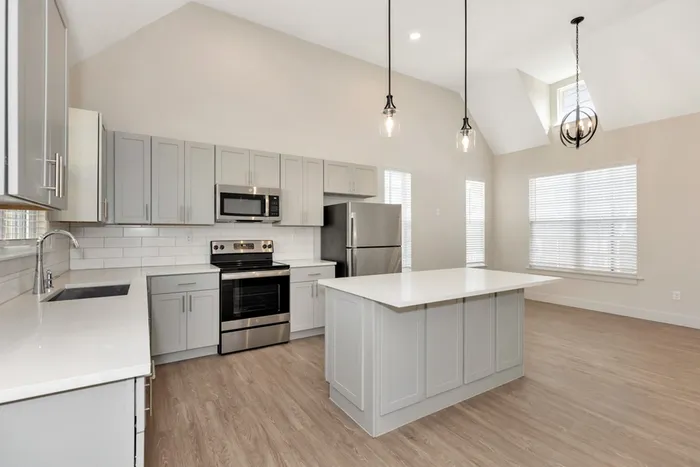 Kitchen with light cabinetry and tall ceilings