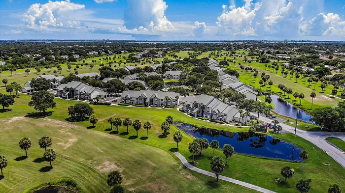 Melbourne, FL Apartments Near Patrick Space Force Base - Caribbean Isle - Aerial View of Apartment Complex with Multiple Bodies of Water, Walking Paths, and Street Access