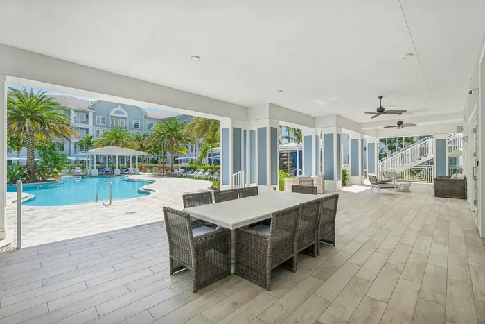 LArge covered patio with table and chairs with view of the pool