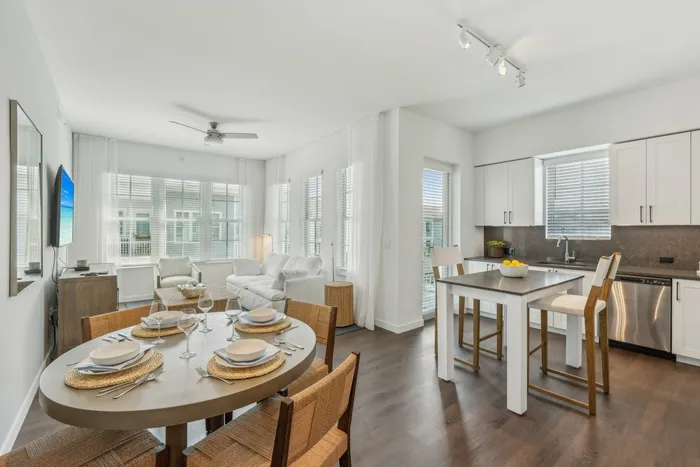 2-Bedroom Apartments in Lantana, FL - Ivory Lantana - Dining Area with Wood-Style Flooring, Round Table with Chairs, and View of Kitchen and Living Area.