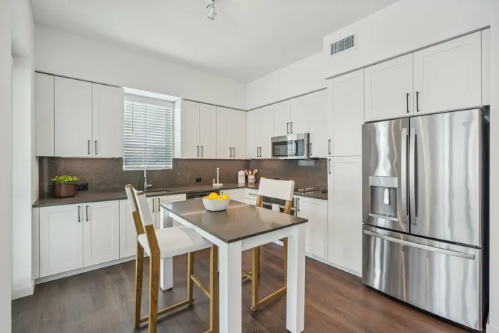 Kitchen with stainless steel appliances and kitchen island with chairs