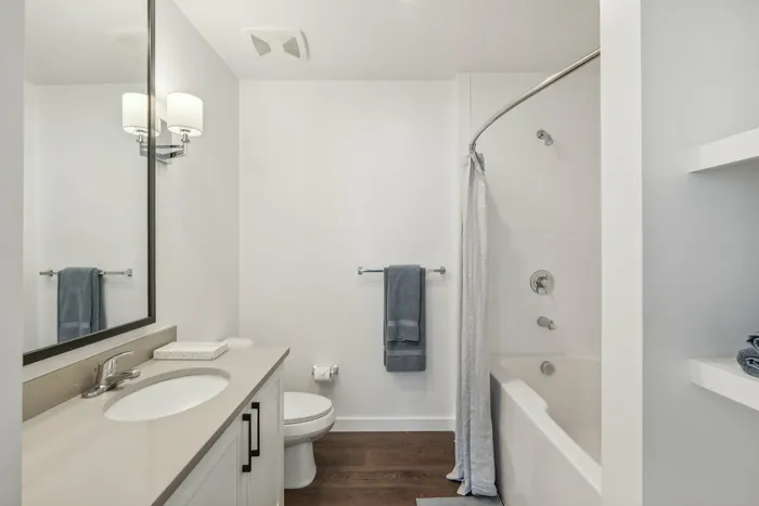 Bathroom with one sink and mirror above and tub