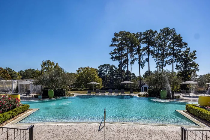 Outdoor pool on a sunny day with pool chairs and umbrella