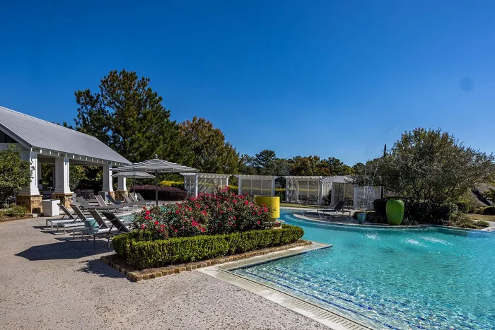 Outdoor pool on a sunny day with pool chairs and umbrella