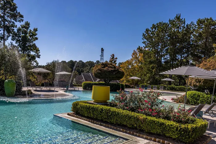 Outdoor pool on a sunny day with pool chairs and umbrella