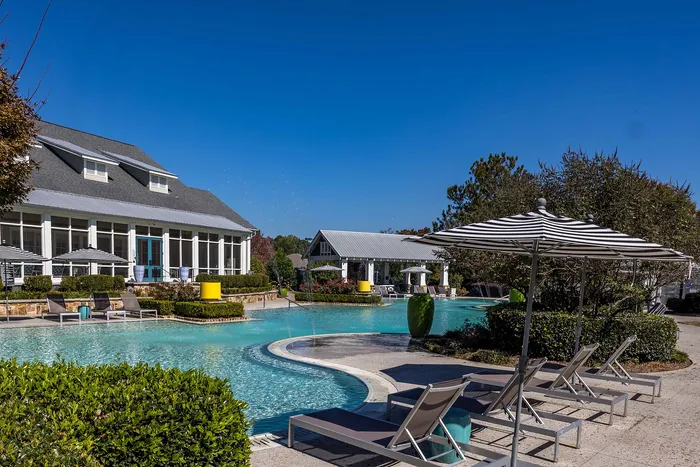 Outdoor pool on a sunny day with pool chairs and umbrella