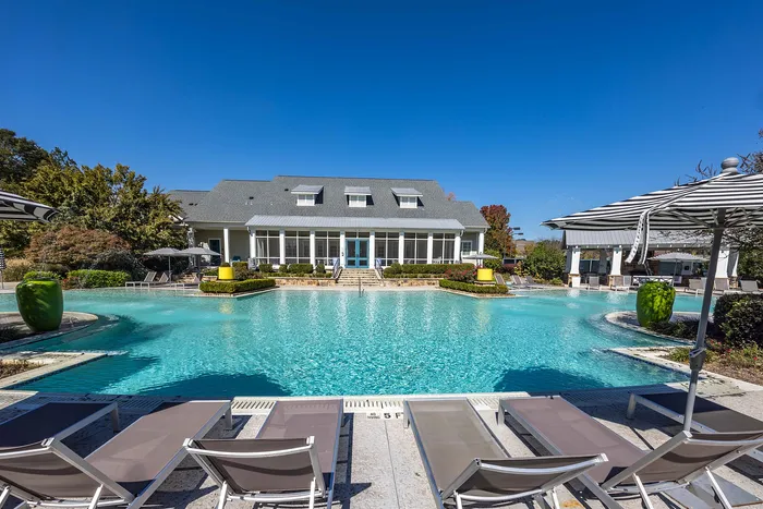 Outdoor pool on a sunny day with pool chairs and umbrella