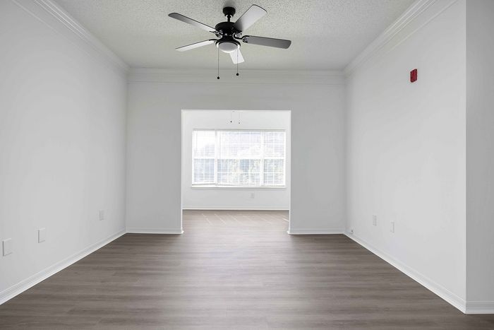 unfurnished living area with ceiling fan and wood style flooring