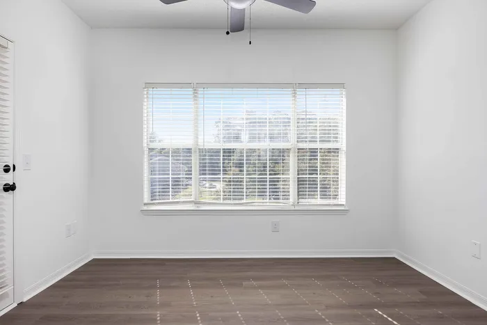 unfurnished dining area with ceiling fan and wood style flooring and window