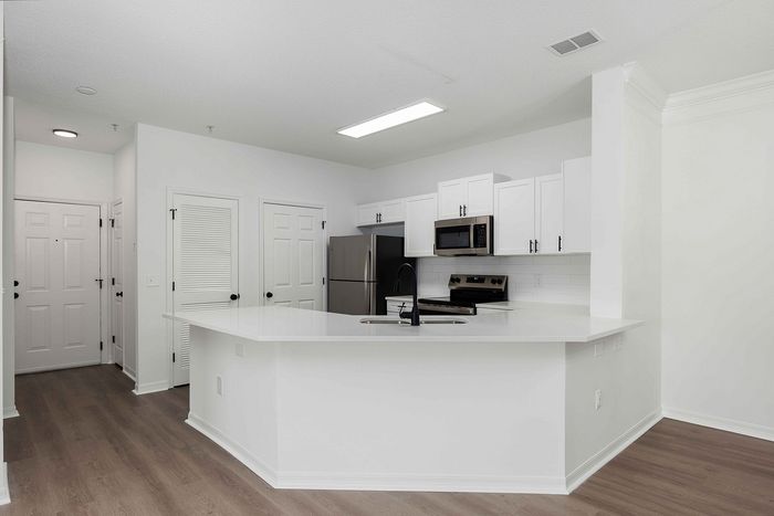 Kitchen with white cabinets and stainless steel and black appliances
