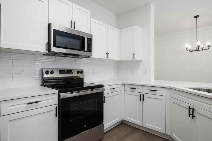 Kitchen with white cabinets and stainless steel and black appliances