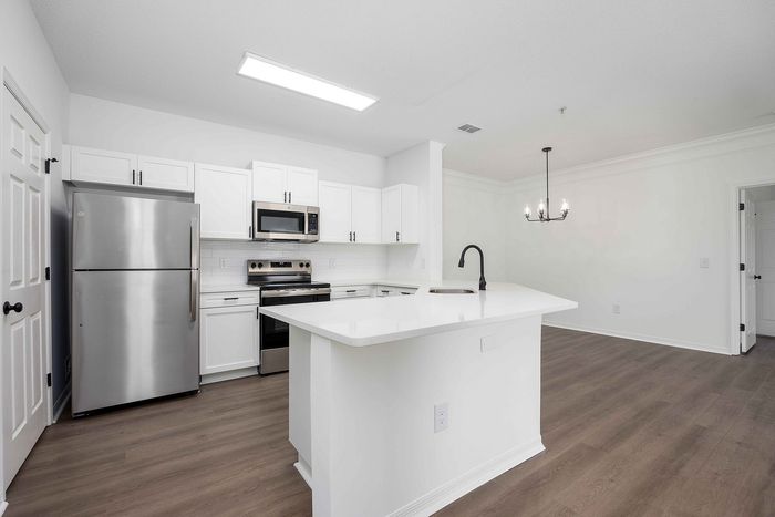 Kitchen with white cabinets and stainless steel and black appliances