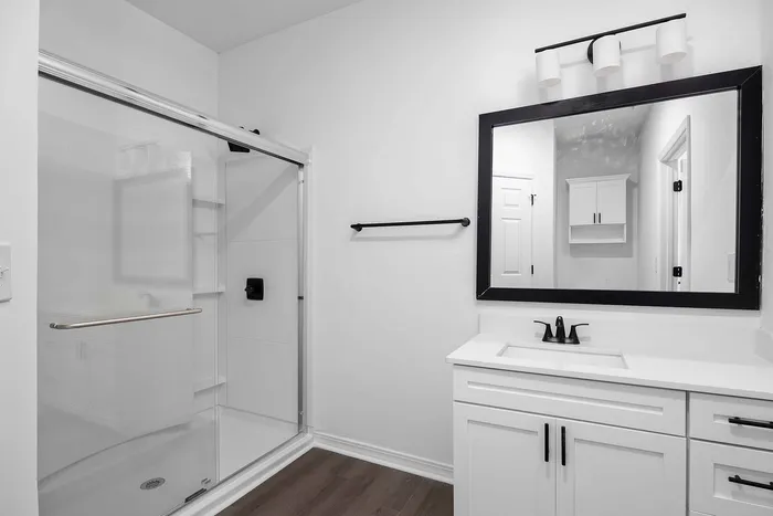 Bathroom with standard tub and sink with large mirror above the mirror