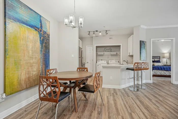 Furnished dining area with dining chairs and table with a view of the kitchen