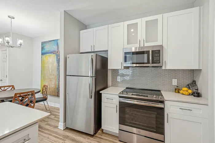 Kitchen with white cabinets and counters and stainless steel appliances