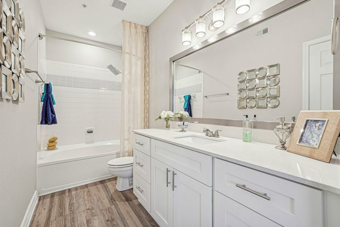 Bathroom with tub/shower and sink with large mirrior