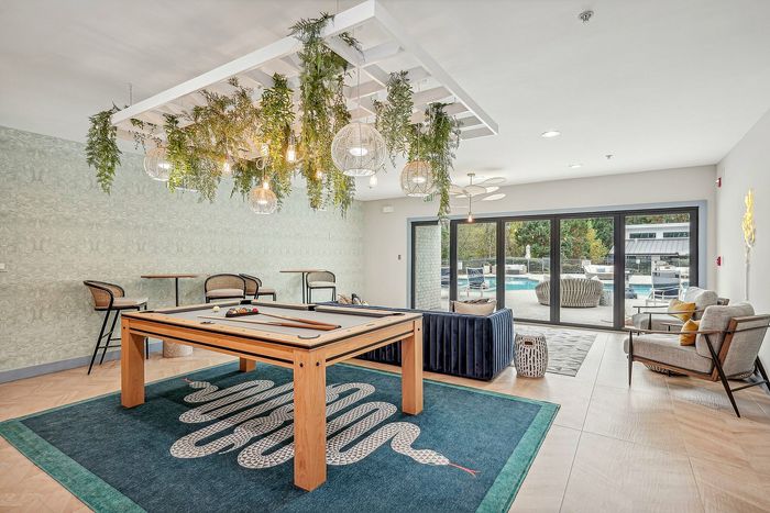 Indoor Community club room with pool table, view of the pool and plants
