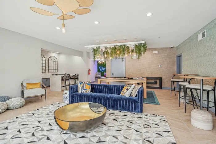 Indoor Community club room with pool table, couch and plants