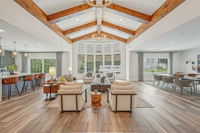 Indoor community sitting area with many windows and high ceilings with many places to sit