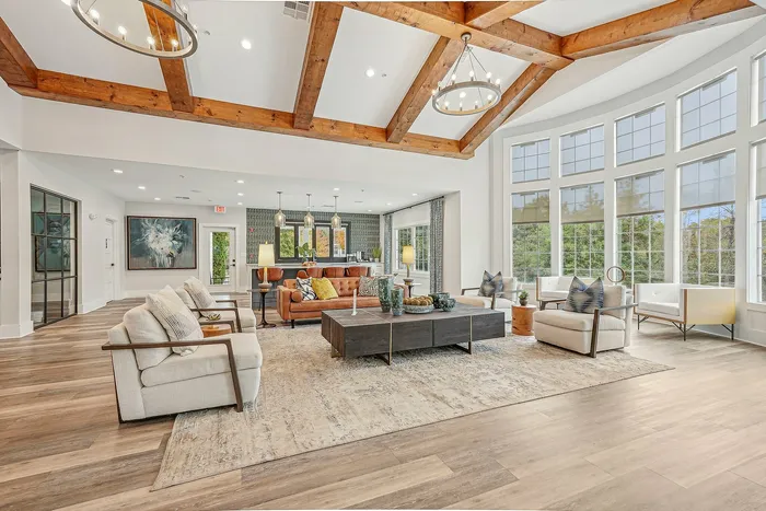 Indoor community sitting area with many windows and high ceilings with many places to sit