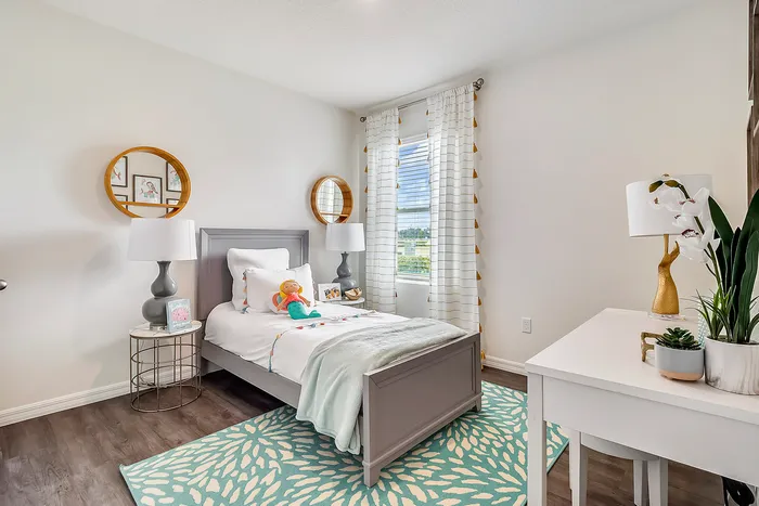 Charming bedroom with modern decor, featuring a cozy bed, elegant lamps, and a bright window with curtain details.