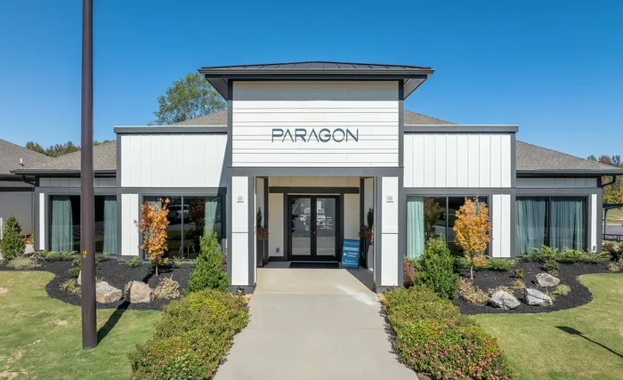 Modern apartment complex entry with landscaped garden and large glass doors at Paragon.