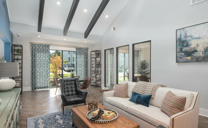 Spacious and elegant clubroom with high ceilings, wooden beams, plush seating, and large window view.