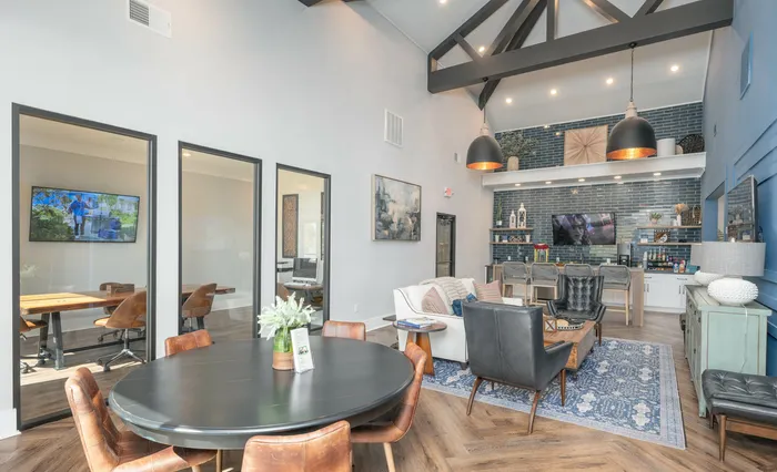 Stylish modern clubroom area in an apartment complex with high ceilings and elegant furnishings.