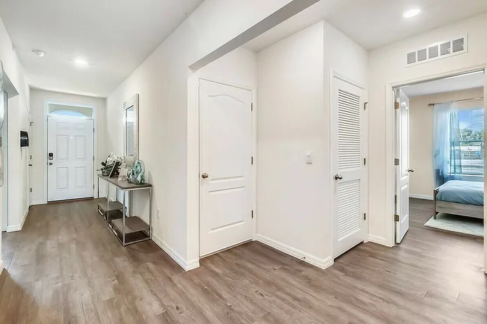 Single Family Homes for Rent in Fairview, NC, with In-Unit Washer and Dryer - Fairview Meadows - Entryway with Wood-Inspired Flooring, White Walls, Display Shelf, and Mounted Mirror.