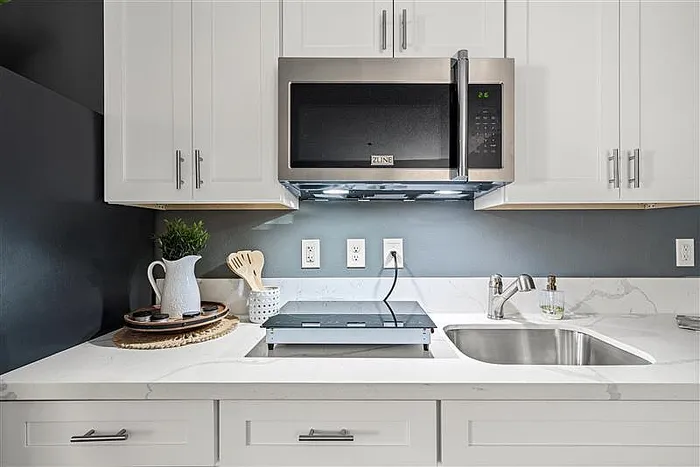 Furnished kitchen with white cabinets