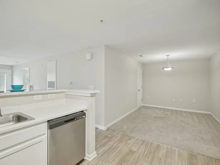 Kitchen with white cabinets and stainless steel appliances plus dining room