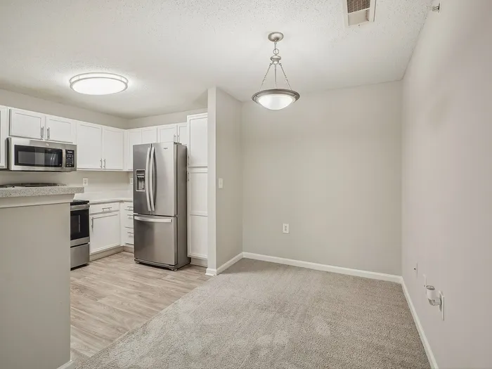 Kitchen with white cabinets with dining room