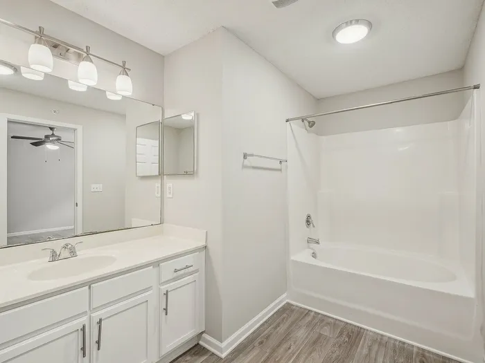 Bathroom with white cabinets and shower/tub combo