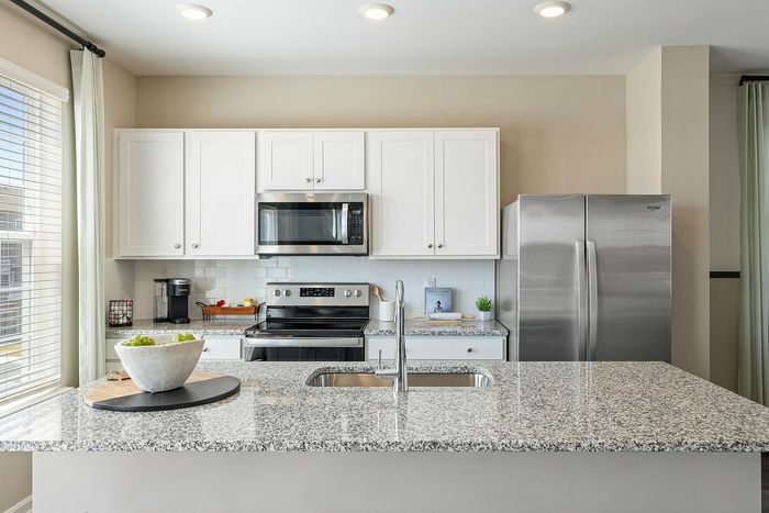 Kitchen with white cabinets and large island at The Meadows at Berkeley Ridge in Martinsburg, WV