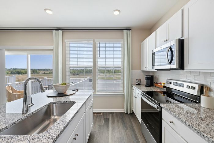 Kitchen with white cabinets and large island at The Meadows at Berkeley Ridge in Martinsburg, WV