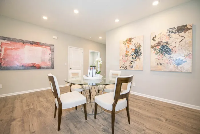 Furnished dining room with table and chairs with vibrant art on walls